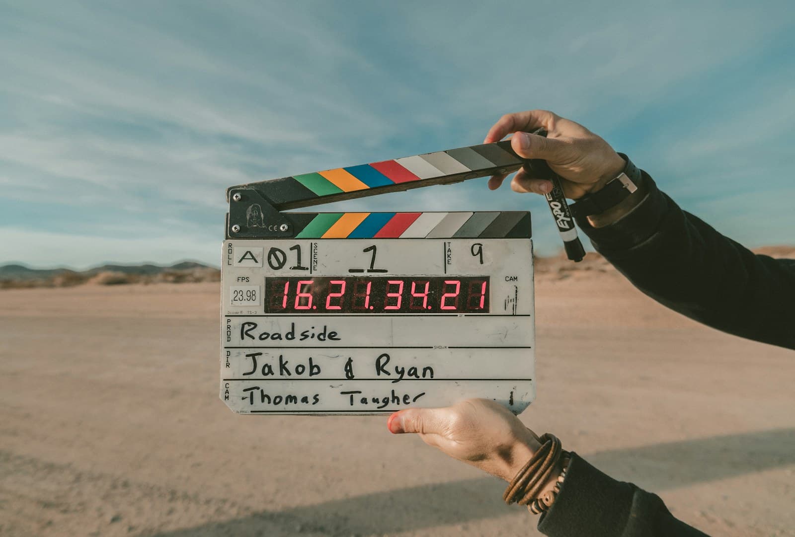 Film slate held in front of an open landscape during a production shoot